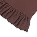 Close-up view of a brown baby dress featuring a delicate ruffled hem and textured fabric, highlighting the fine details and soft material.