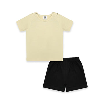 Newborn baby outfit featuring a soft pastel yellow T-shirt with snap buttons on the shoulders and black elastic-waist shorts. The design highlights comfort and breathability, perfect for warm days. The background includes playful doodles, text indicating 'New Arrivals,' and branding from Palm and Pale, emphasizing 'Sunny styles for little smiles.'